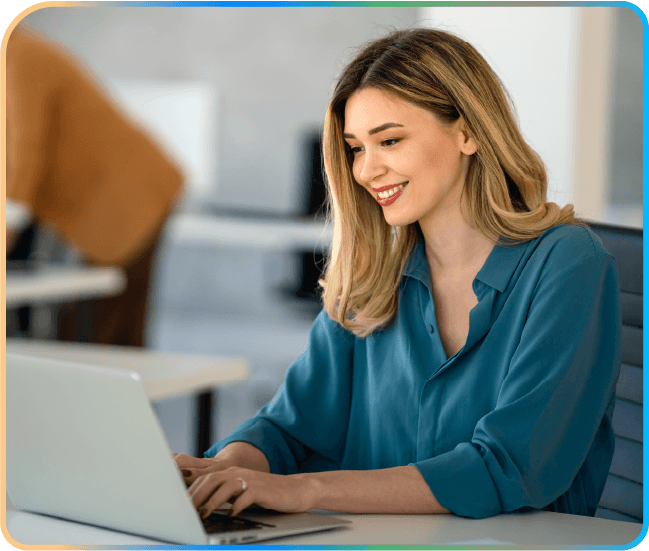 Mulher sorrindo enquanto usa um notebook em um escritório